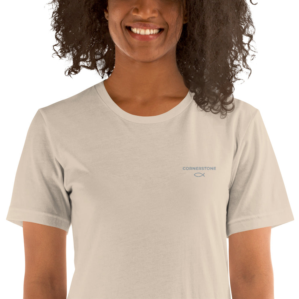 Cornerstone Wear unisex soft cream t‑shirt worn by woman, front view.