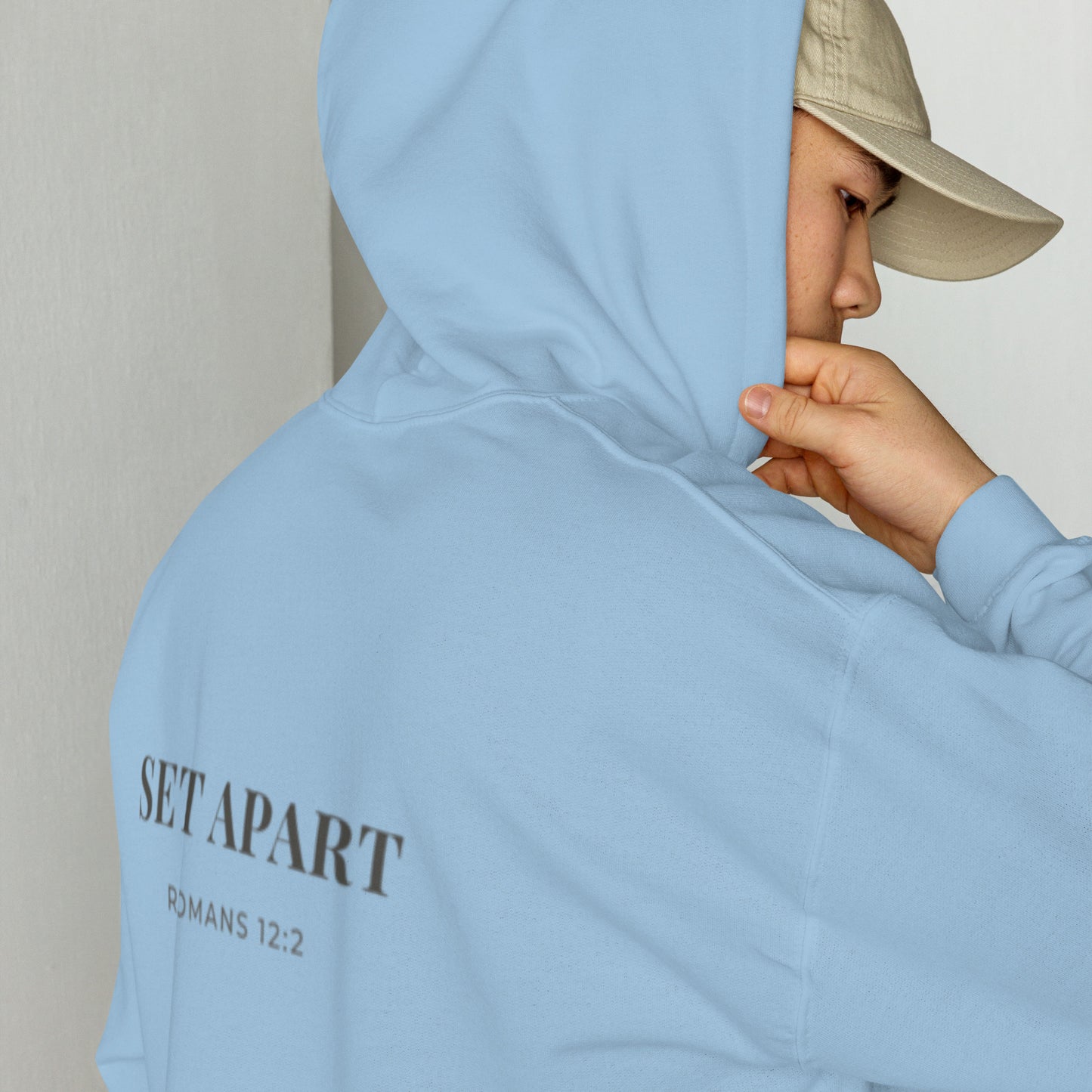 Person wearing a Cornerstone Wear unisex blue hoodie with text, standing against a plain background