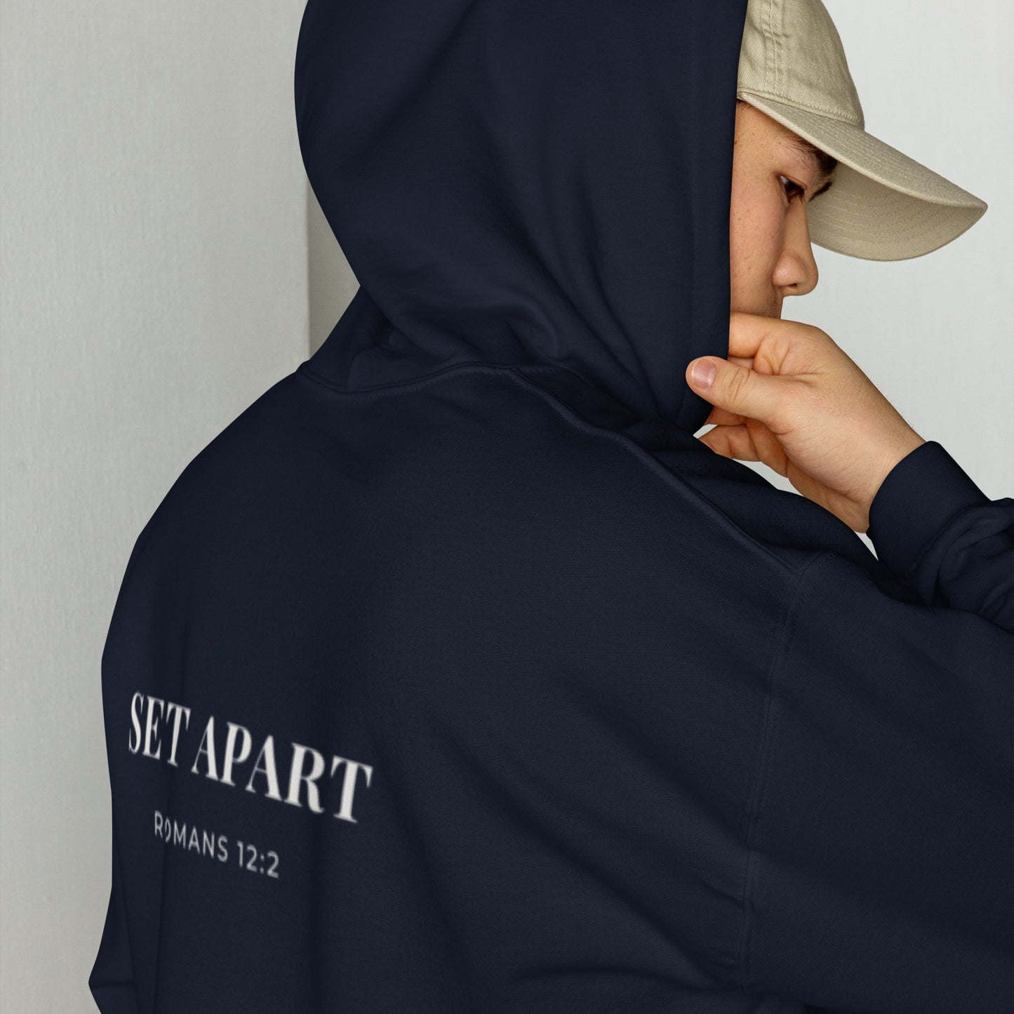Person wearing a Cornerstone Wear unisex navy hoodie with text, standing against a plain background